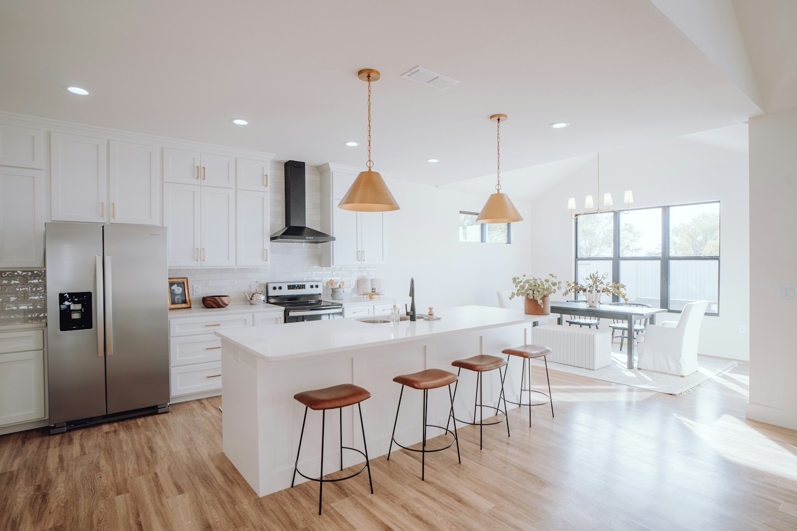 A bright home kitchen with an island, pendant lights and natural light