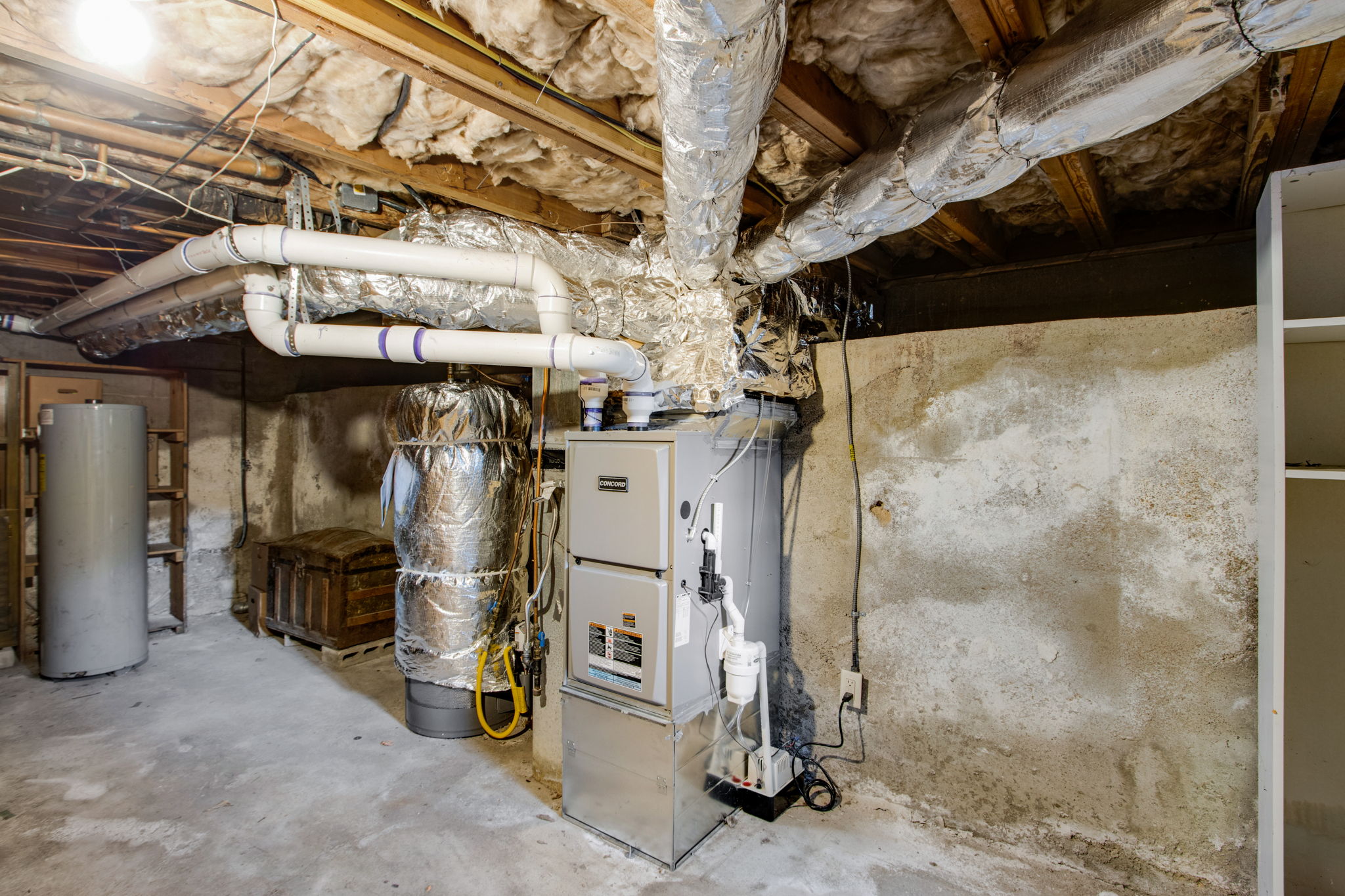A home furnace and air handler connected to insulated ductwork in a basement